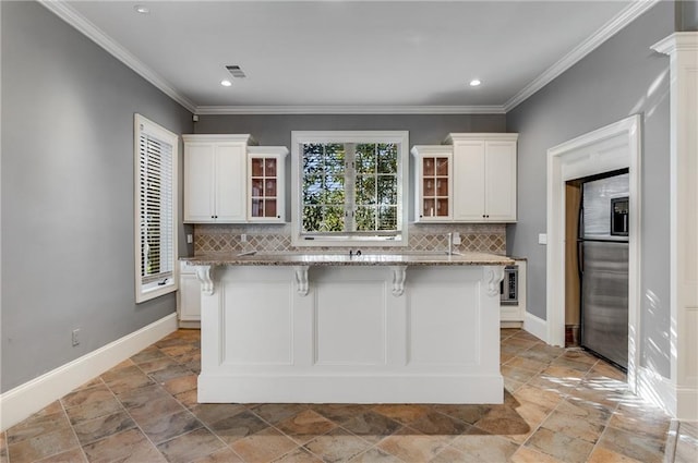 kitchen featuring a kitchen island, light stone countertops, backsplash, and a kitchen bar