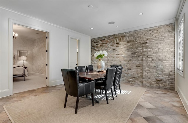 tiled dining space with brick wall, an inviting chandelier, and crown molding