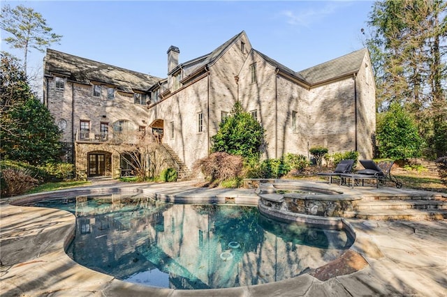 view of swimming pool featuring a patio area and an in ground hot tub