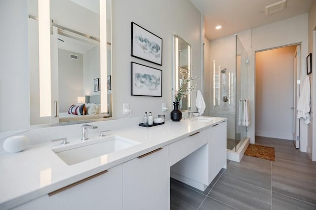 bathroom featuring connected bathroom, a sink, visible vents, a shower stall, and double vanity