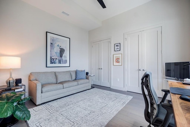 home office featuring ceiling fan, visible vents, baseboards, and wood finished floors