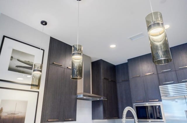 kitchen featuring modern cabinets, hanging light fixtures, and fridge