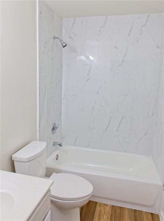 full bathroom featuring toilet, hardwood / wood-style floors, vanity, and tiled shower / bath