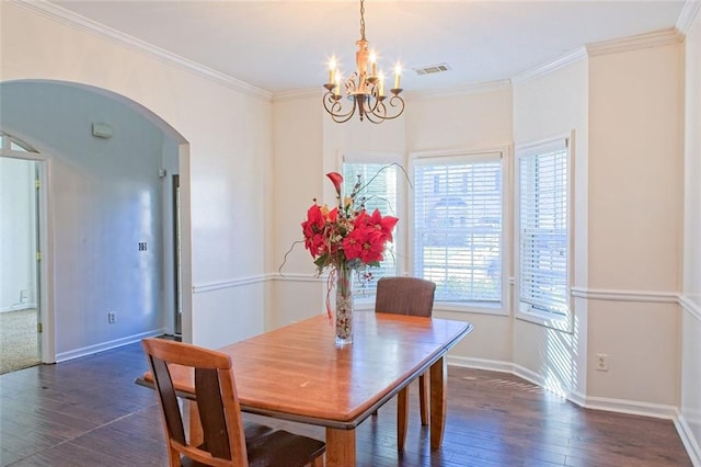 dining room with dark hardwood / wood-style flooring, ornamental molding, and a chandelier