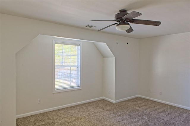 additional living space featuring ceiling fan and light colored carpet