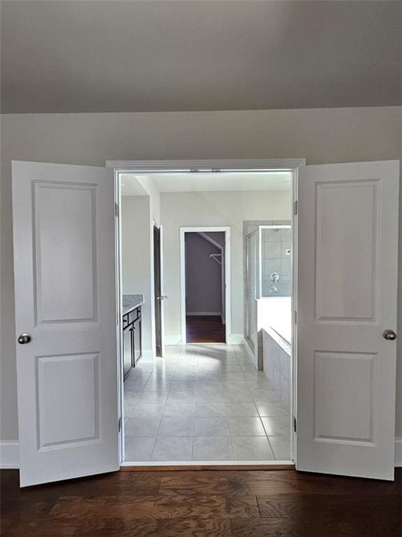 hall featuring light wood-style flooring and baseboards