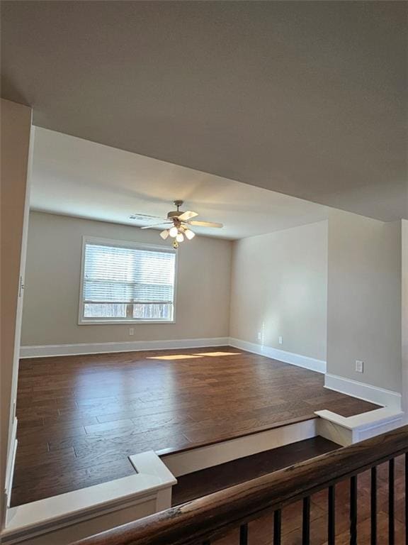 unfurnished room with wood finished floors, baseboards, and ceiling fan