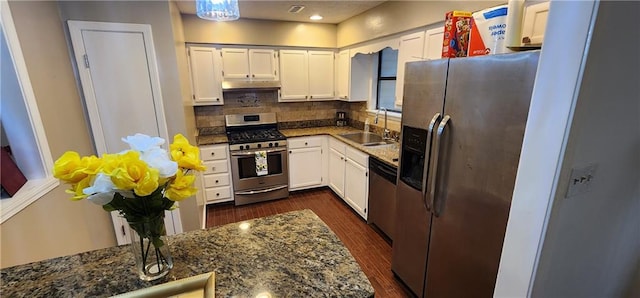 kitchen with dark hardwood / wood-style flooring, tasteful backsplash, dark stone counters, stainless steel appliances, and white cabinetry