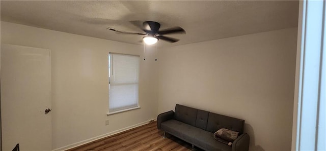 living area with ceiling fan and wood-type flooring