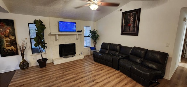 living room with a textured ceiling, ceiling fan, wood-type flooring, and lofted ceiling