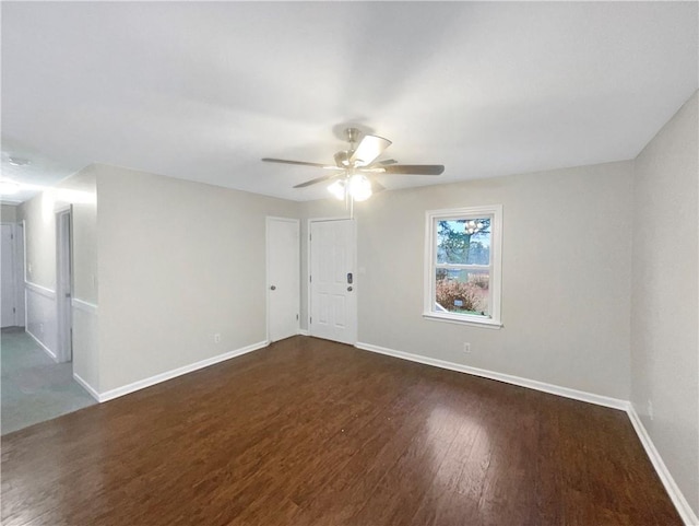 empty room with ceiling fan and dark hardwood / wood-style flooring