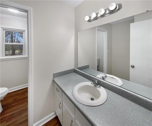 bathroom featuring ornamental molding, vanity, toilet, and hardwood / wood-style floors