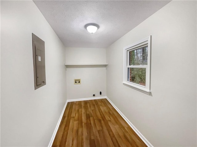 laundry room with washer hookup, electric panel, a textured ceiling, hardwood / wood-style flooring, and hookup for an electric dryer