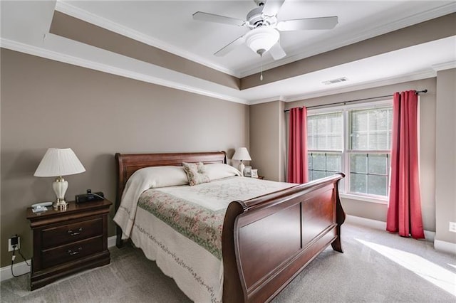 bedroom with carpet floors, a tray ceiling, and crown molding