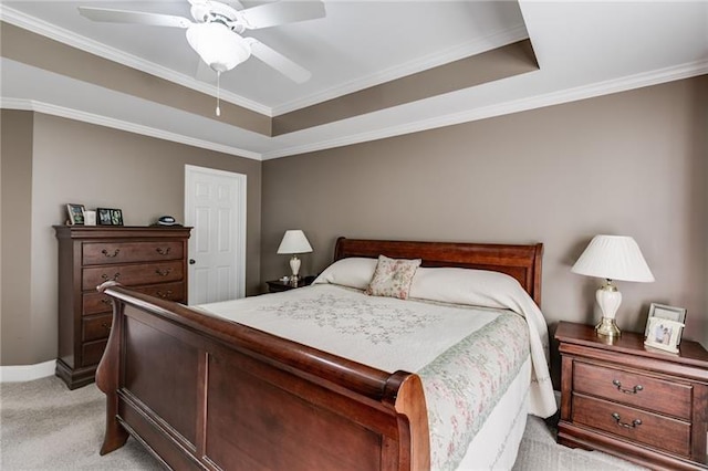 bedroom with light carpet, baseboards, a tray ceiling, and crown molding