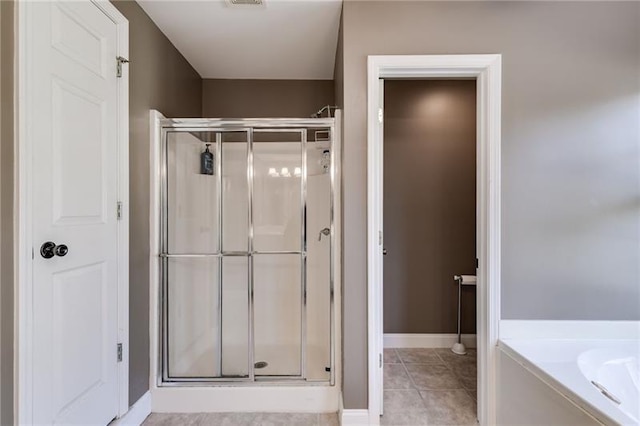 bathroom featuring a garden tub, visible vents, a shower stall, baseboards, and tile patterned floors