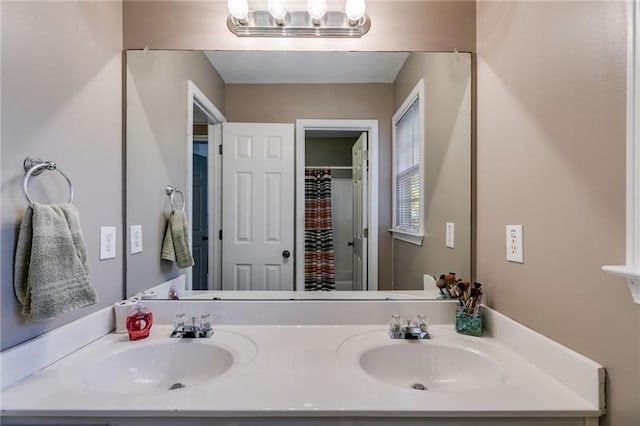 bathroom with double vanity, curtained shower, and a sink