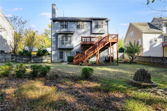 back of house with a deck, a fenced backyard, stairs, a lawn, and a chimney