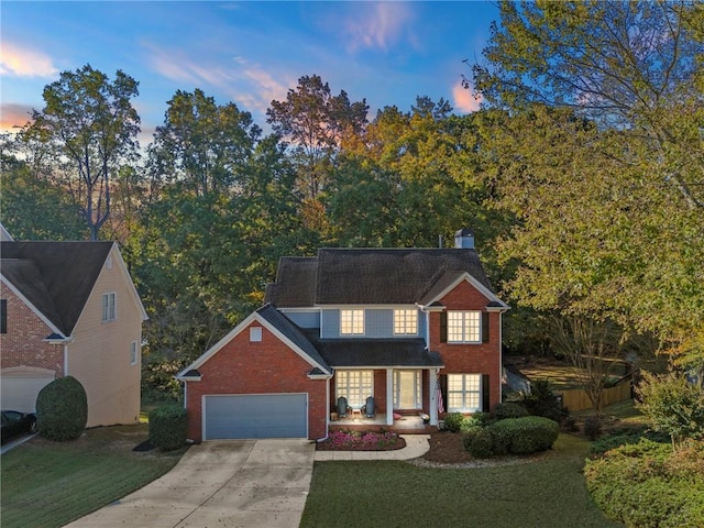 view of front of house with brick siding, a yard, a chimney, a garage, and driveway