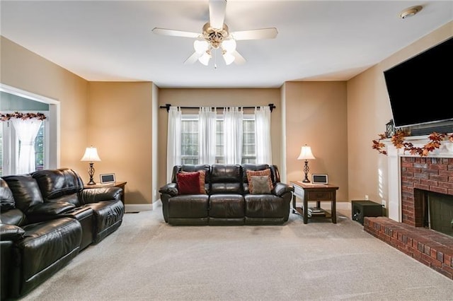 carpeted living area featuring a brick fireplace, a ceiling fan, and baseboards