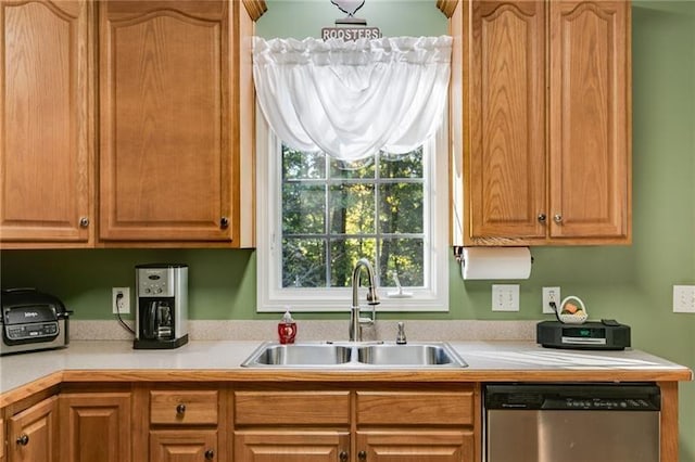 kitchen with light countertops, dishwasher, and a sink