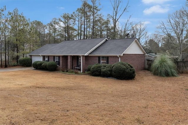 single story home featuring a garage, driveway, roof with shingles, and brick siding