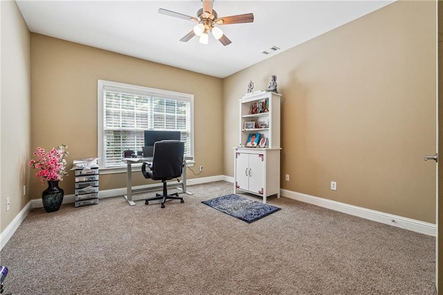 carpeted office space with baseboards, a ceiling fan, and visible vents