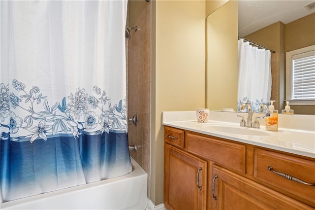 full bath featuring visible vents, vanity, and shower / bath combo
