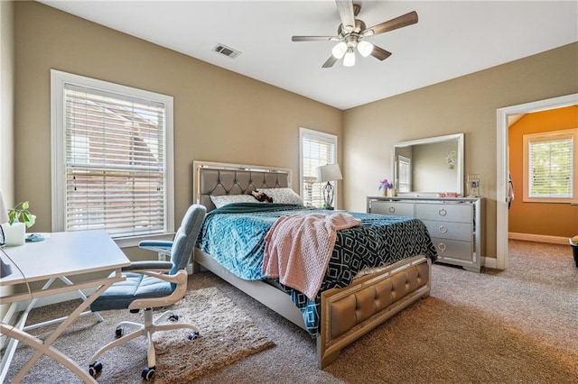 carpeted bedroom with baseboards, visible vents, and ceiling fan