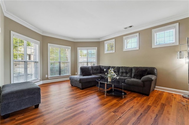 living room featuring baseboards, wood finished floors, visible vents, and ornamental molding