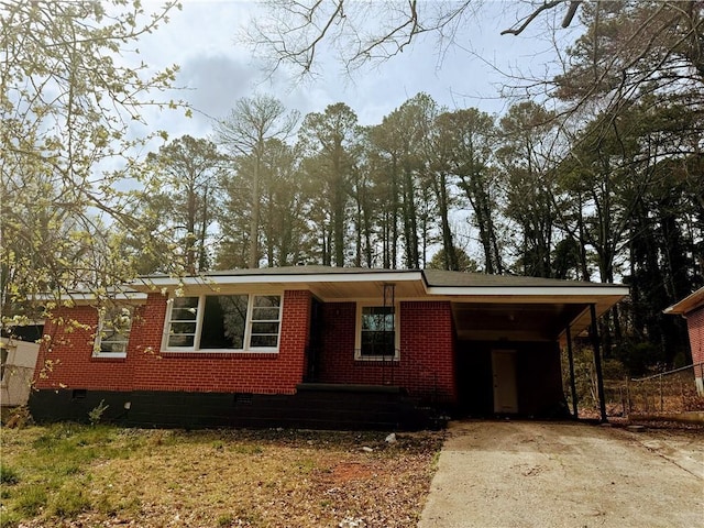 view of front of property with crawl space, an attached carport, concrete driveway, and brick siding