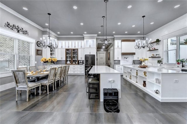 kitchen featuring white cabinetry, hanging light fixtures, and a large island