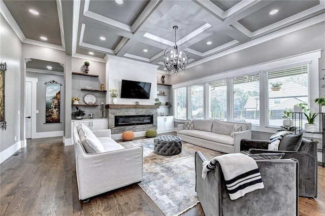 living room featuring a fireplace, built in features, a notable chandelier, dark hardwood / wood-style flooring, and coffered ceiling