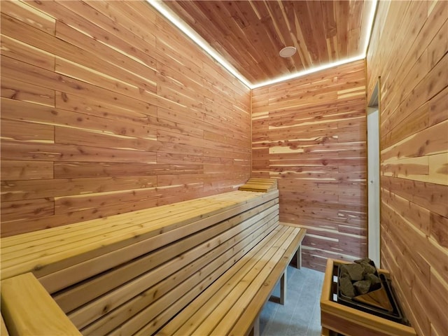 view of sauna with wooden walls and wood ceiling