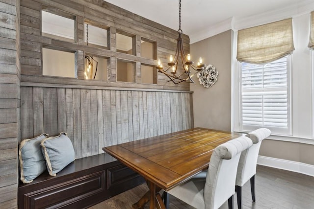 dining room with an inviting chandelier, crown molding, and dark hardwood / wood-style flooring