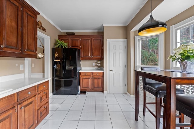 kitchen featuring light tile patterned floors, crown molding, decorative light fixtures, and black fridge