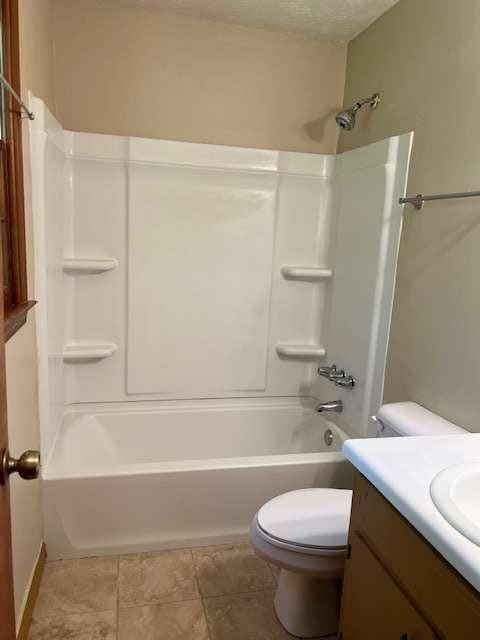 full bathroom featuring tile patterned flooring, bathing tub / shower combination, vanity, and toilet