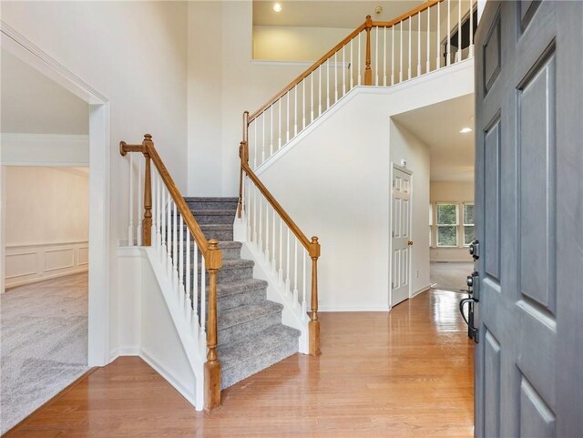 3515 Mcclure Woods Dr, Duluth, GA 30096 - foyer with light wood finished floors, stairs, a towering ceiling, and a decorative wall