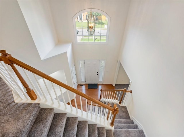3515 Mcclure Woods Dr, Duluth, GA 30096 - stairway featuring a chandelier, a high ceiling, and wood finished floors
