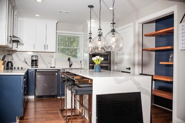 kitchen with pendant lighting, sink, appliances with stainless steel finishes, a center island, and white cabinets