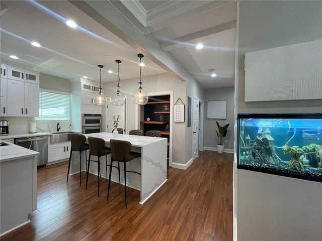 kitchen with stainless steel appliances, white cabinetry, a center island, and dark hardwood / wood-style flooring