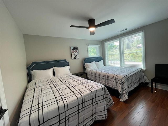 bedroom with dark hardwood / wood-style flooring and ceiling fan