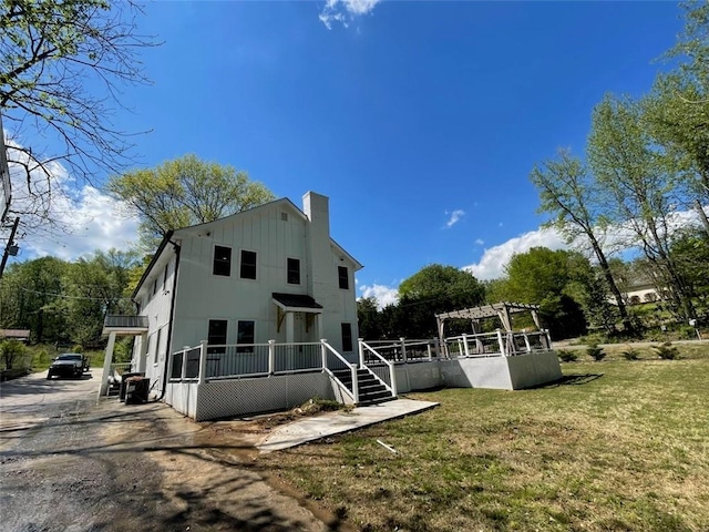 back of house featuring a yard and a pergola