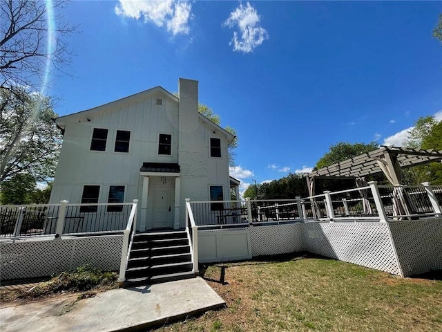 back of house featuring a yard and a pergola