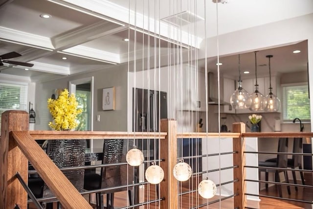 interior space with crown molding, coffered ceiling, ceiling fan, and beam ceiling