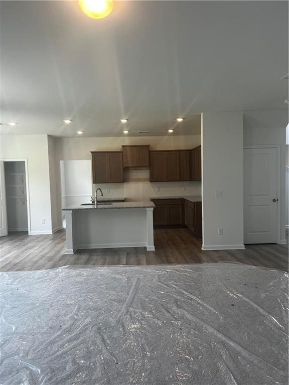 280 River Run Dr, Dallas, GA 30132 - kitchen with a kitchen island with sink, baseboards, wood finished floors, recessed lighting, and a sink