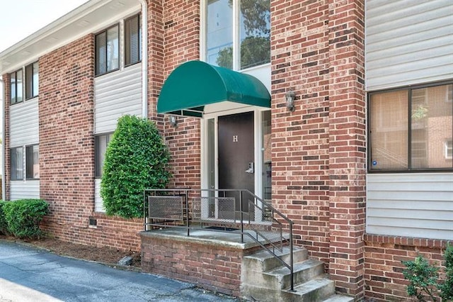 entrance to property featuring brick siding