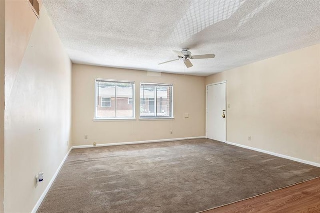 spare room featuring carpet, a textured ceiling, baseboards, and a ceiling fan