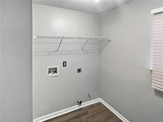 washroom featuring electric dryer hookup, gas dryer hookup, hookup for a washing machine, hardwood / wood-style flooring, and a textured ceiling