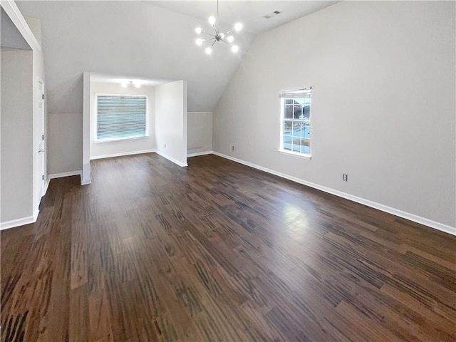 bonus room with lofted ceiling, dark wood-type flooring, and an inviting chandelier